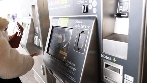 person interacting with a ticket machine