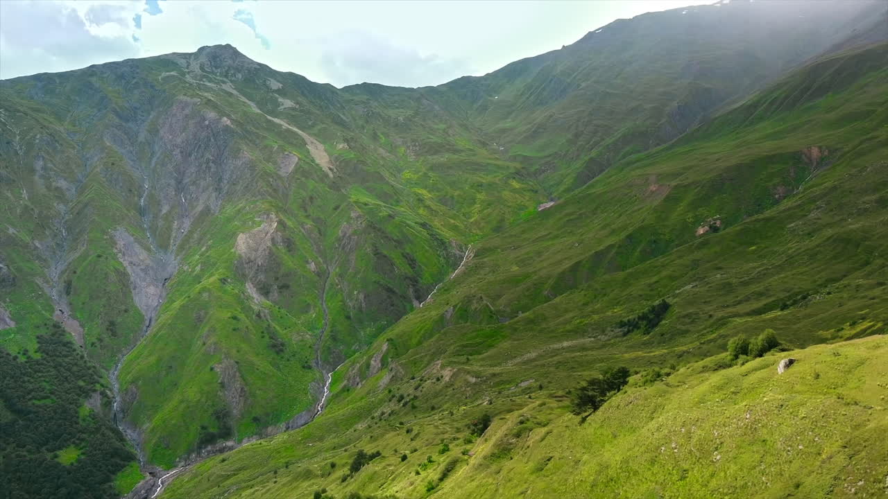 Vista aerea con drone della natura in Georgia. Montagne del Caucaso, vegetazione, vallate, nuvole rigogliose, capanna sulla cima