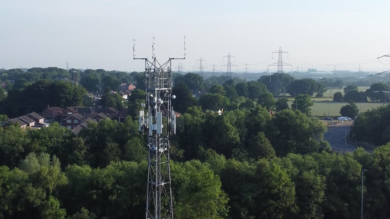 antena de torre de radiodifusión 5g en la campiña británica con vehículos que viajan por la carretera con empuje aéreo de fondo en la vista izquierda
