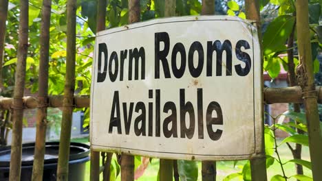 closeup of sign dorm rooms available at budget friendly hotel and hostel accommodation displayed on fence