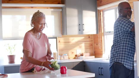 Älteres-Afroamerikanisches-Paar-Packt-Lebensmittel-In-Der-Küche-Aus,-Zeitlupe