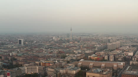 Panoramic-aerial-descending-footage-of-city.-Dominant-tall-Fernsehturm-TV-tower-and-buildings-in-neighbourhoods-around.-Berlin,-Germany