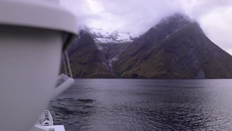 Slow-motion-shot-of-beautiful-mountains-reaching-the-cloudy-sky,-surrounded-by-ocean