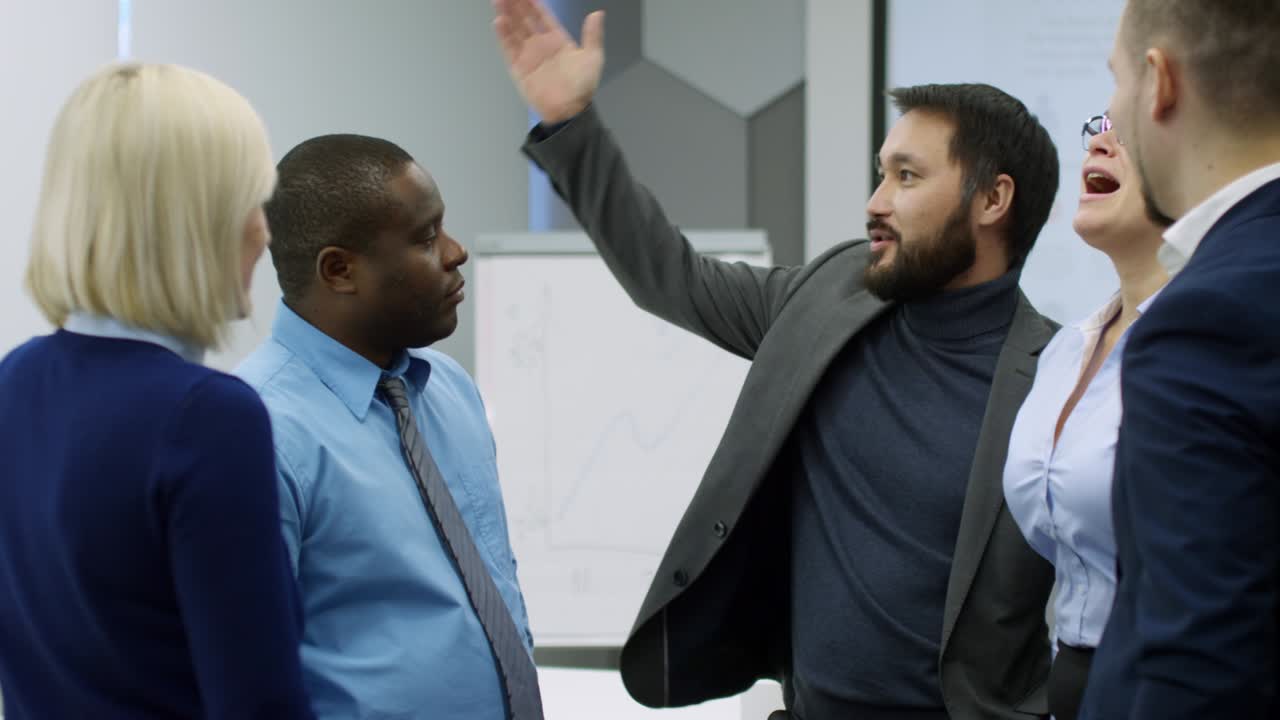 Smiling Asian Entrepreneur Talking to Colleagues