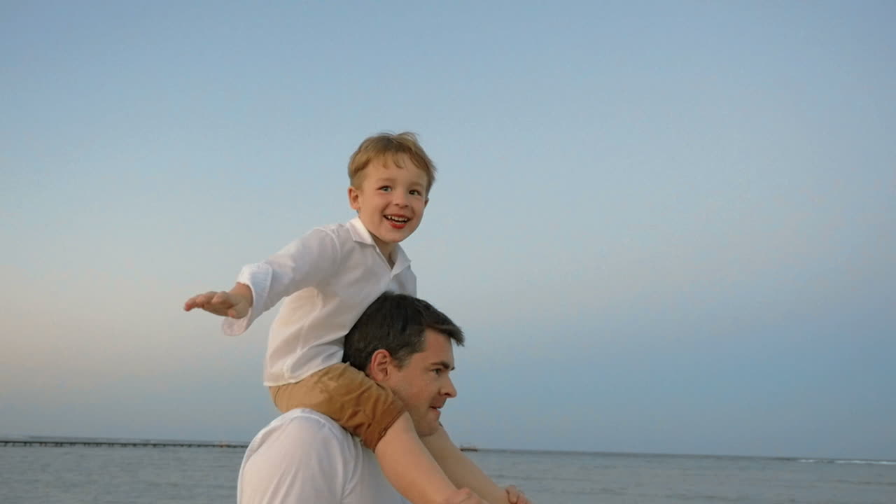 Bambino che mostra un aereo seduto sulle spalle del padre