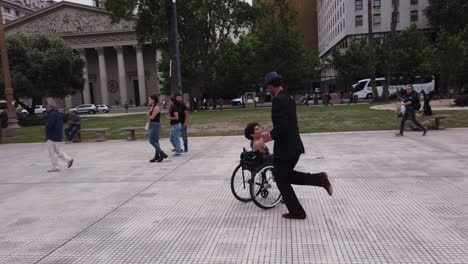 couple dancing in a wheelchair in a city park