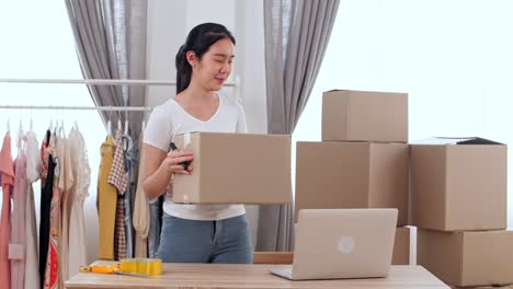 Young Woman Working Online Shopping And Packing With Cardboard Box At Home