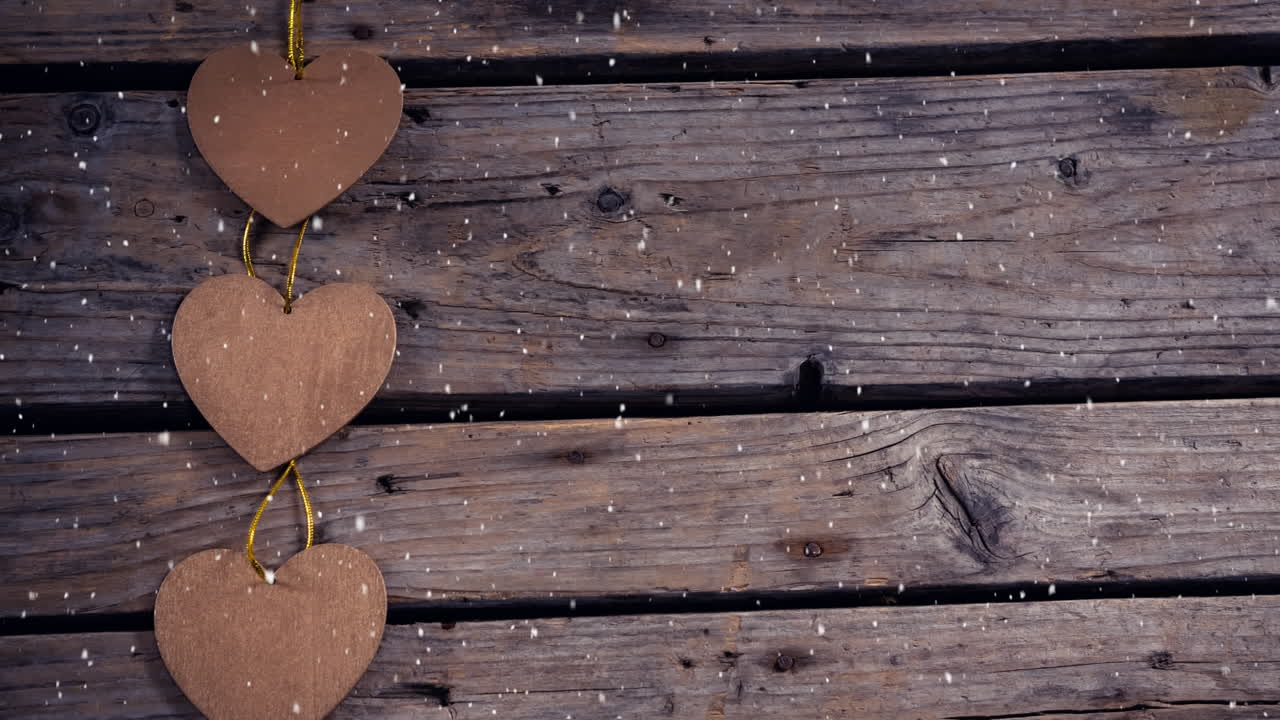 Neve che cade con decorazioni natalizie a forma di cuori