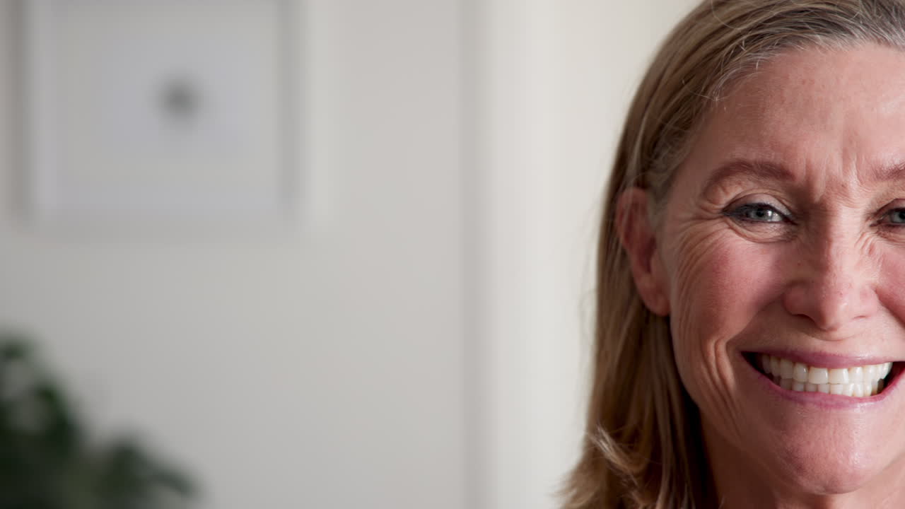 Senior woman decorating Christmas tree at home during festive holiday season, copy space