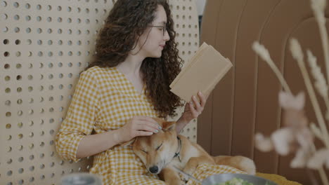 woman reading with dog at home