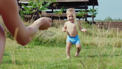 Die-Ersten-Schritte-Des-Babys-Der-Junge-Von-1-Jahr-Geht-Unsicher-Zu-Mama-Zeitlupenvideo