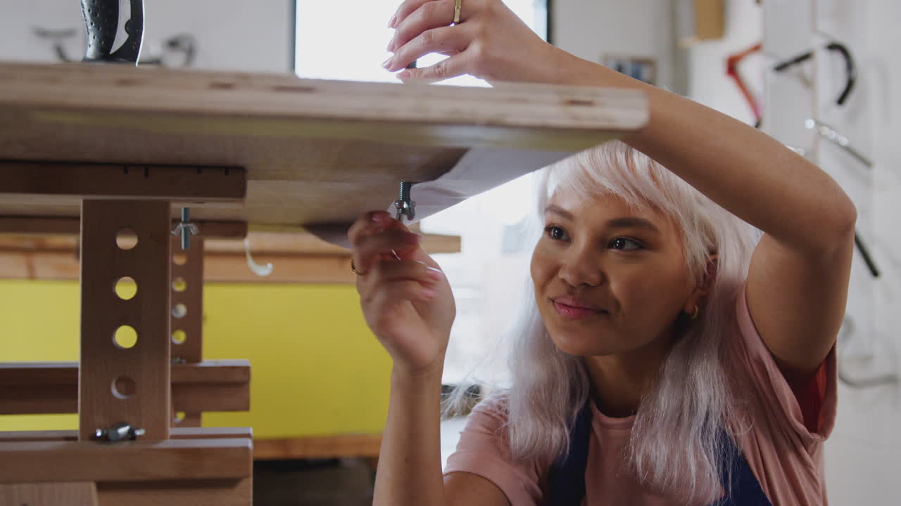 aprendiza femenina en el taller de construcción de bicicletas de bambú sostenibles que ensamblan jigs