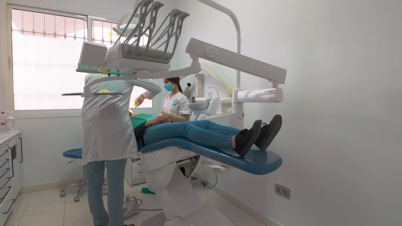 mujer quitando un diente en el dentista