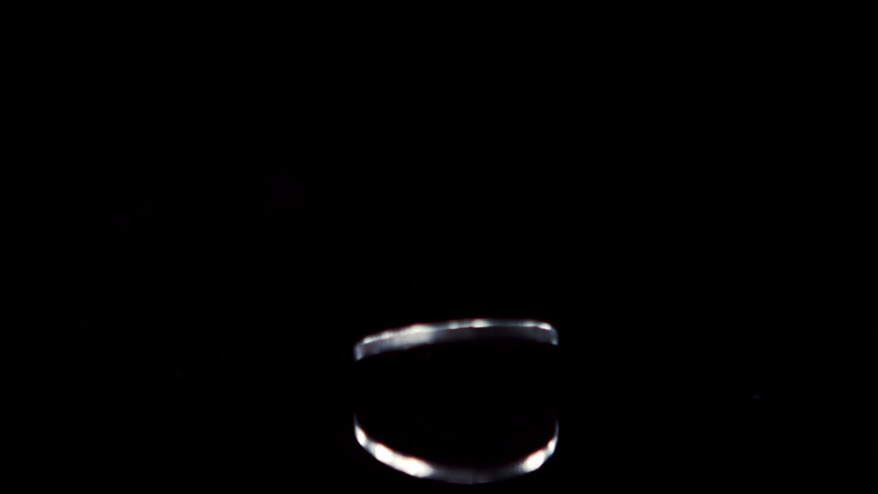 검은 바탕 에 동전 이 회전 하고 있다