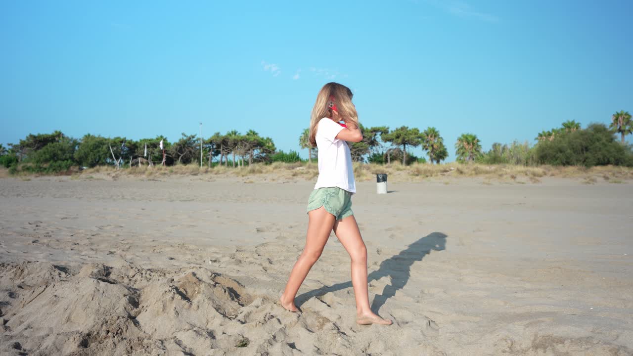 Niña caminando descalza en una playa soleada