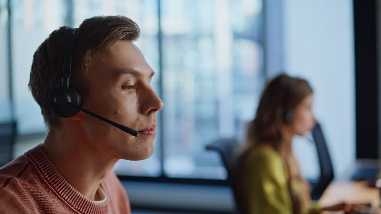 Operatørhånd tar hodetelefoner fra datamaskin på nært hold. Mann som jobber i et call center