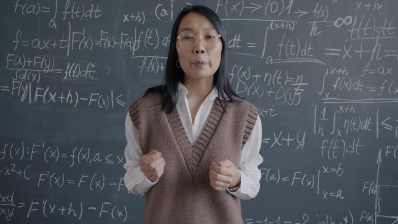 Teacher Explaining Math Concepts on a Blackboard