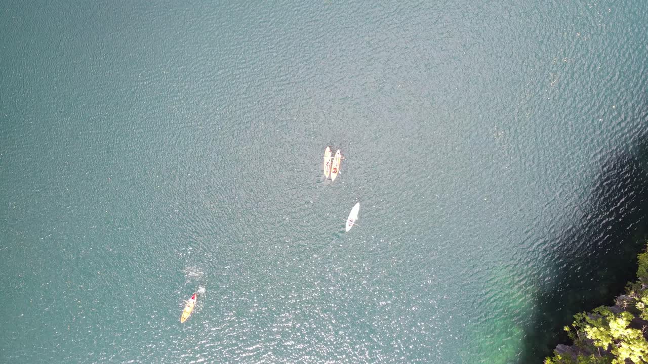 Group of tourist kayaking in Big Lagoon, hidden paradise nestled among towering limestone cliffs in Miniloc Island, Palawan. Bird's-eye view of turquoise waters during island hopping in El Nido