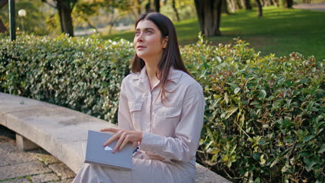 una chica soñadora leyendo una novela sentada en un banco del parque absorta en un tranquilo primer plano de pasatiempo.