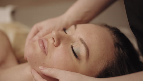 Masaje-Facial-Para-Rejuvenecimiento-Y-Relajación-En-El-Salón-De-Spa-Masajista-Acaricia-La-Barbilla-De-Una-Mujer-Adulta