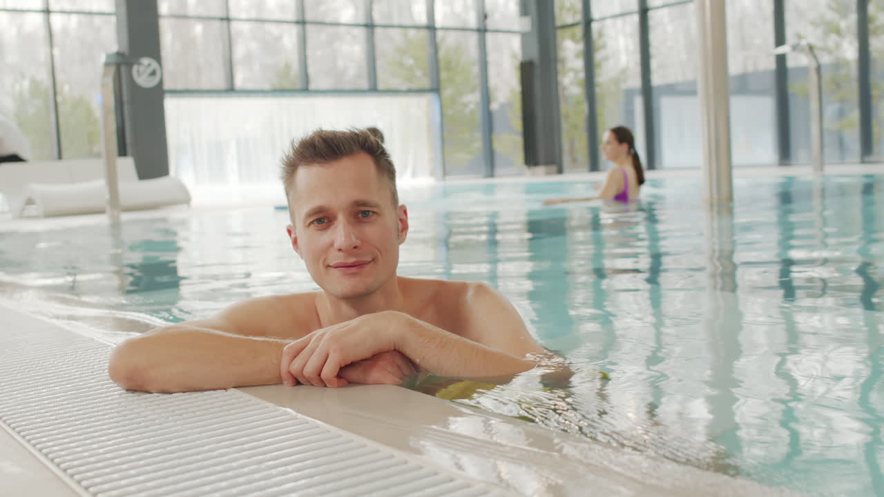 가족 과 함께 실내 수영장 에서 휴식 하는 남자