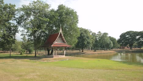 sala thai pavilion in a green historical park in ayutthaya with a lake