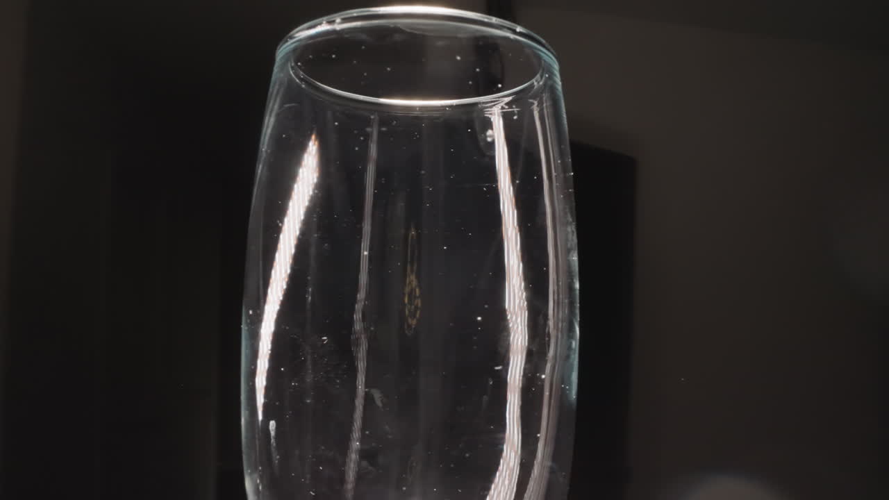 vaso de champán transparente con manchas en un fondo oscuro