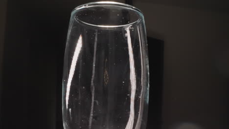 transparent champagne glass with stains on dark background