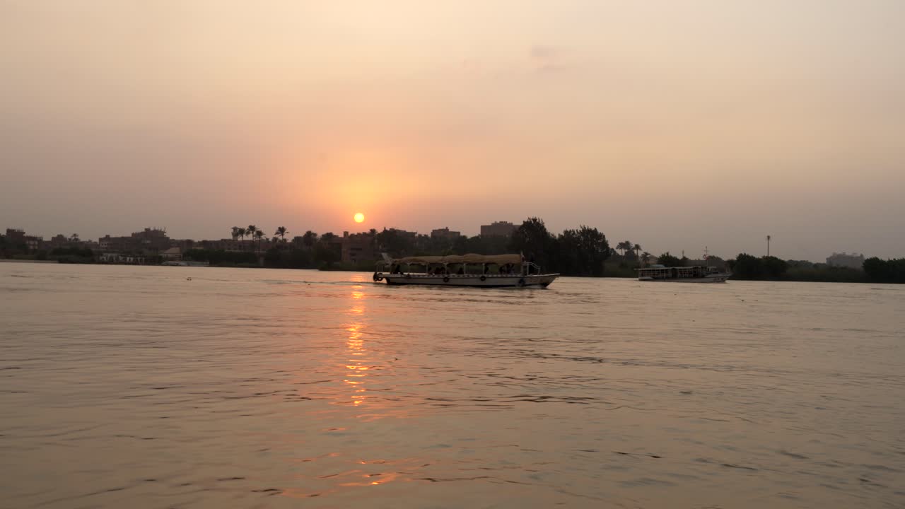 un ferry lleva pasajeros por el río nilo cerca de el cairo, egipto al atardecer