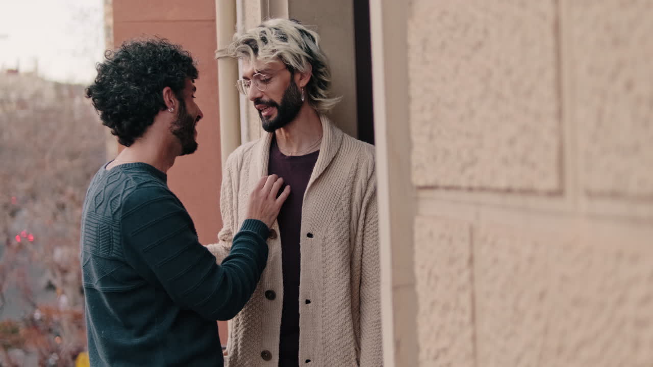Gay Couple Embracing on Apartment Balcony