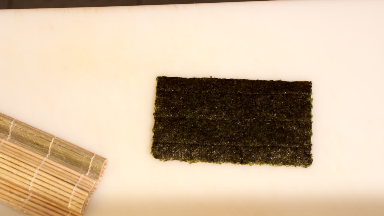 makisu y nori sobre la mesa - estera de bambú y envoltura de algas para hacer sushi - toma panorámica cenital