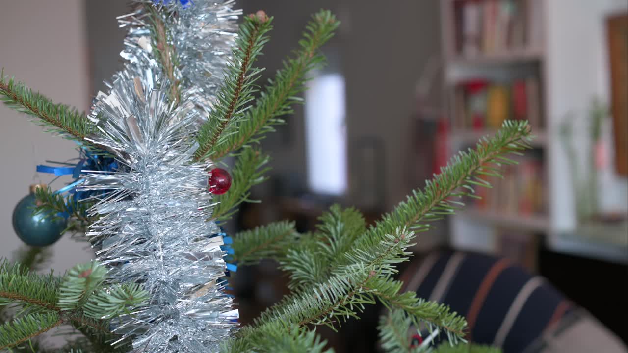 After the festive period, an Asian woman removes Christmas ornaments from the tree