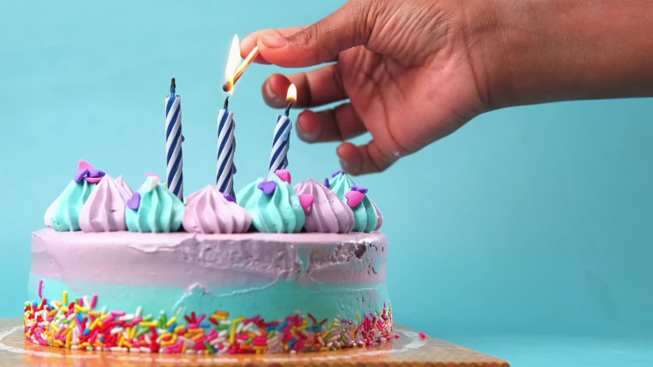 primer plano de pastel de cumpleaños sobre un fondo púrpura claro.