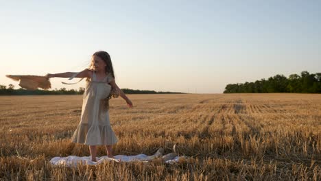 serious sad girl a child stands on a wheat mown field