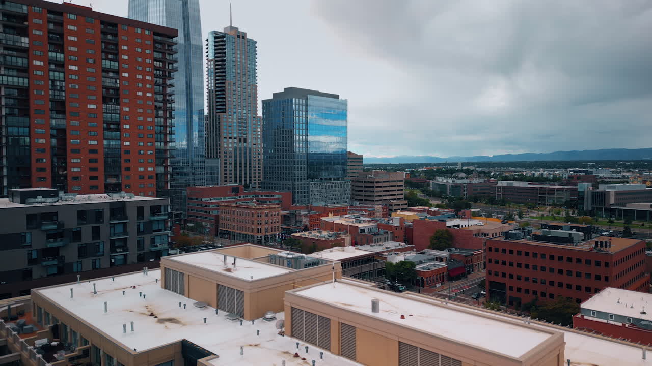 Denver, USA, 28 July 2025: Rising above the multi-storied residential building with terraced balconies. Architecture of Denver, Colorado, USA from drone on gloomy day