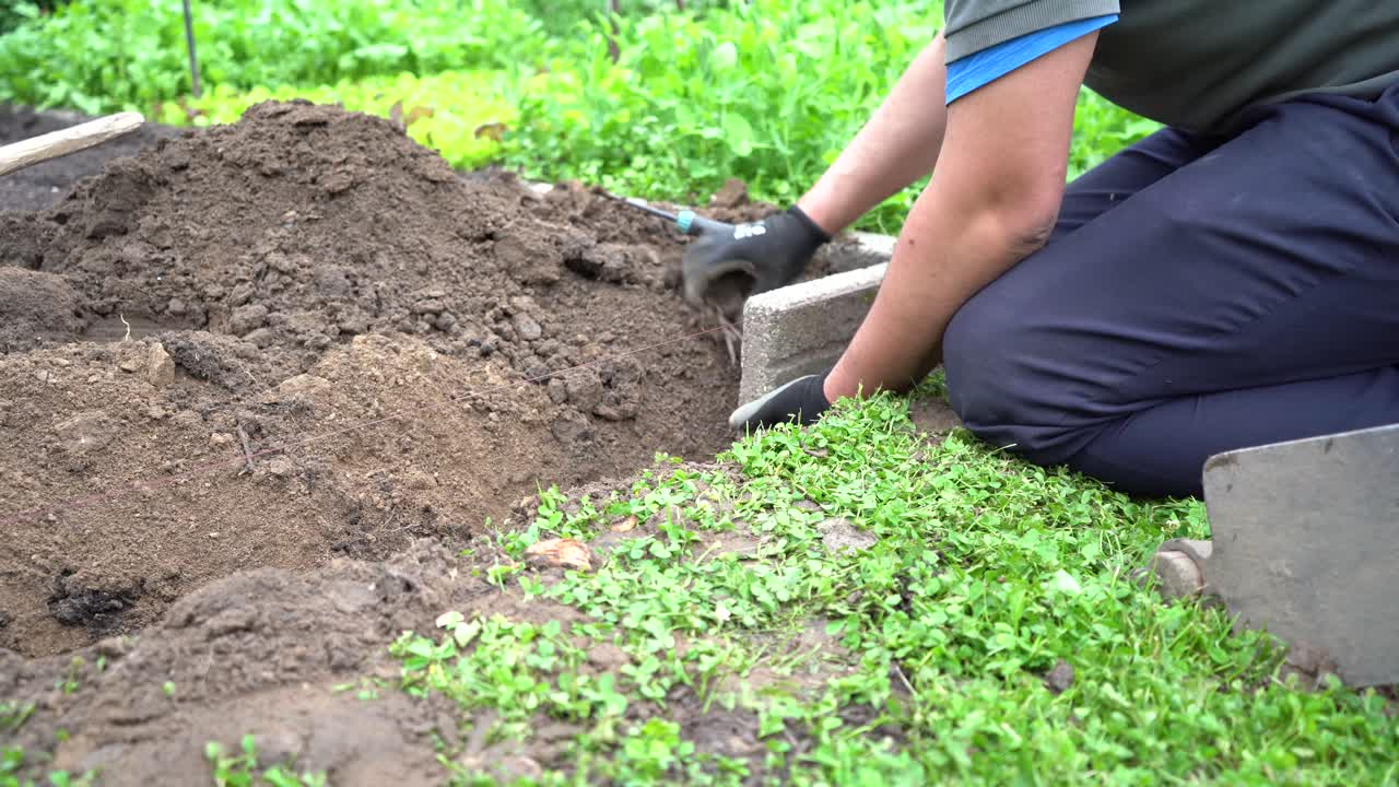 jardinero construyendo un muro de jardín tradicional con losas de piedra