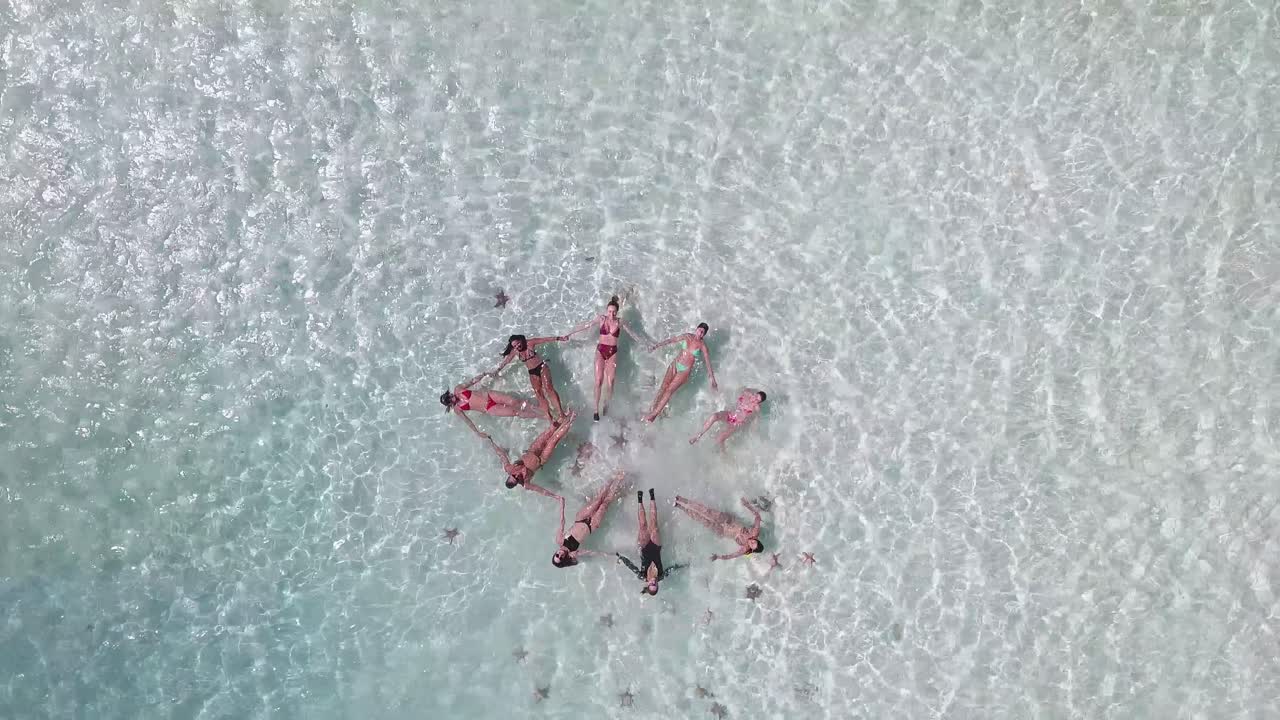 별을 형성하는 푸른 바다에 떠 있는 손을 잡고 있는 여성, 싱크로나이즈드 수영, 드론 탑 뷰