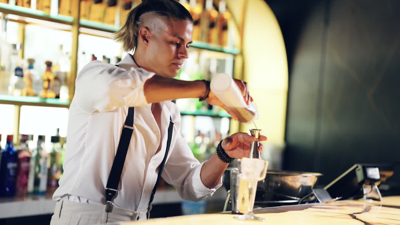 Barman profesional vertiendo ingredientes en un jigger en un bar.