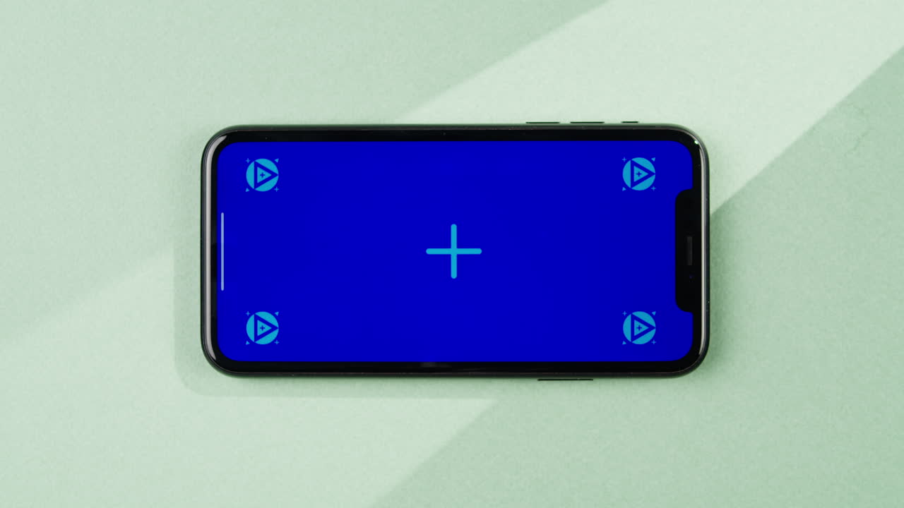 Phone with green screen chroma key on orange background close up, top view. Summer bright texture studio shot for travel business, delivery, food, cosmetology, application.