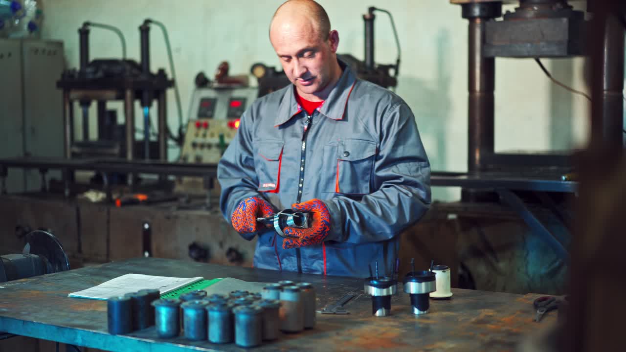 Engineer In Factory Checks Component Quality. Worker verifies the accuracy of manufacturing steel parts with a special caliper