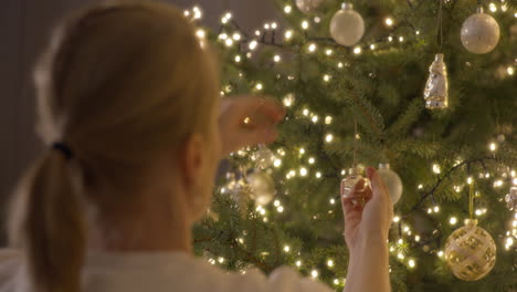 woman decorating a christmas tree