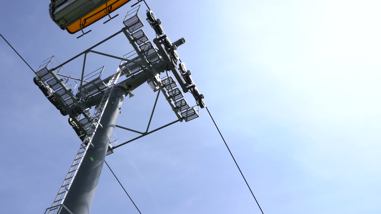 cámara de ángulo bajo mirando hacia el telesilla que se usa para viajar en las montañas