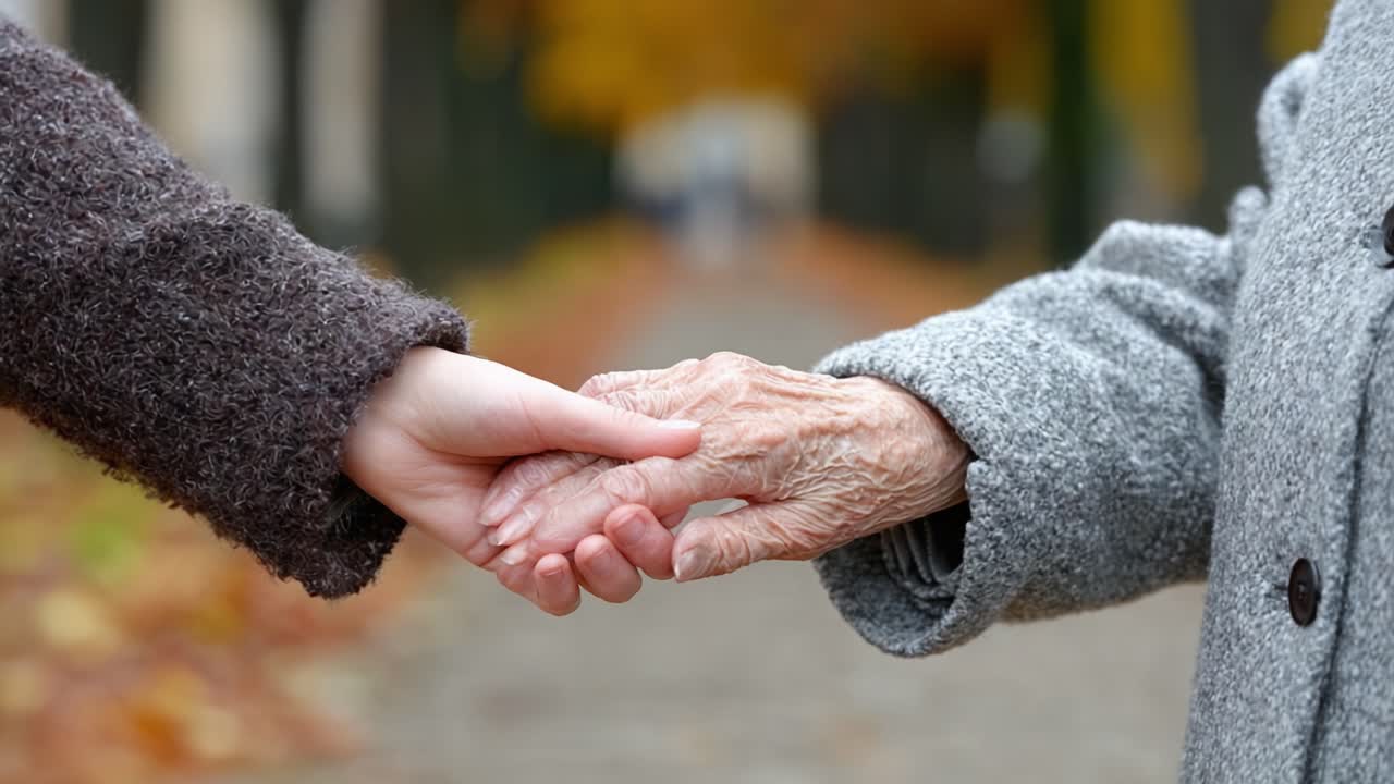 A Heartwarming Moment: A Young Person and an Elderly Hand Gracefully Intertwine Their Fingers in an Intimate Gesture of Love and Connection Amidst a Beautiful Autumn Setting