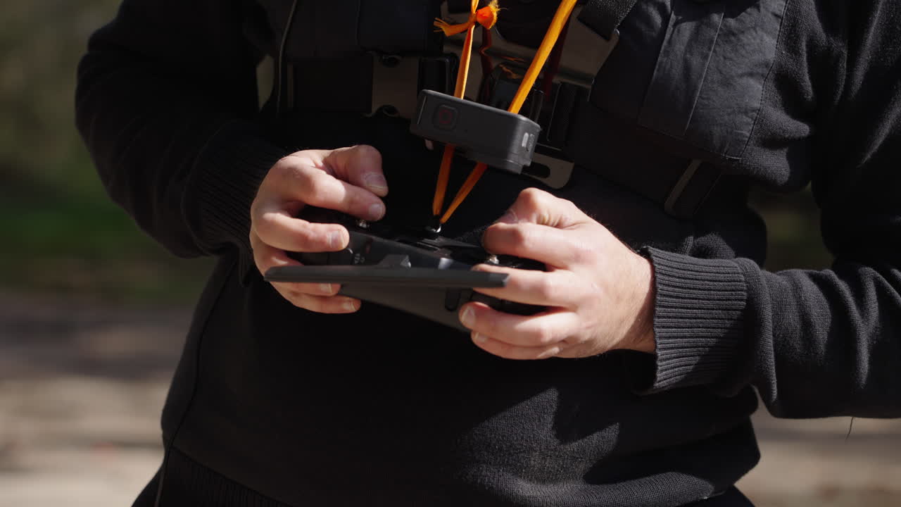 Person Operating Drone Remote Controller with GoPro Camera on Chest
