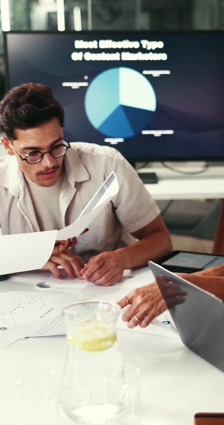 Colegas de Trabalho Analisando Gráficos de Dados em Reunião de Escritório Moderno
