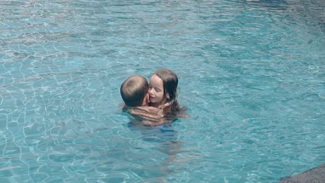 happy-children-hug-and-swim-in-pool-water-slow-motion