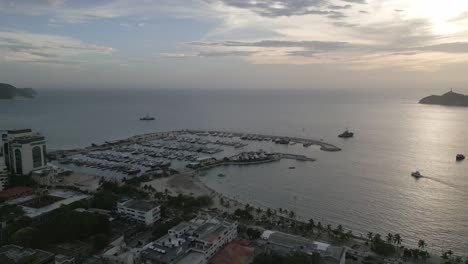 Drone-Aéreo-Sobre-Santa-Marta-Colombia-Frente-Al-Mar-Costa-Caribe-Ciudad-Horizonte-Playa,-Colinas-Marinas-Y-Vecindario-A-La-Luz-Del-Día