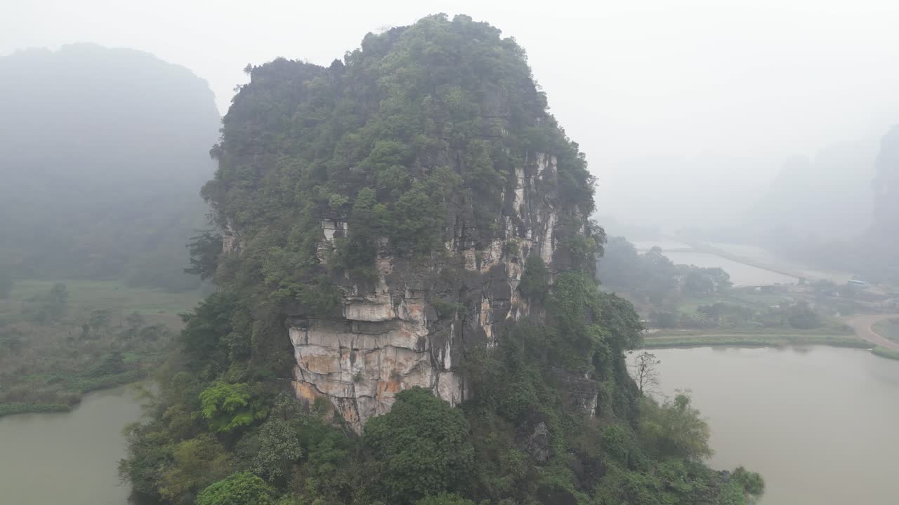 Cảnh quay drone những vách đá hùng vĩ được bao quanh bởi nước ở vùng núi Ninh Bình, miền Bắc Việt Nam