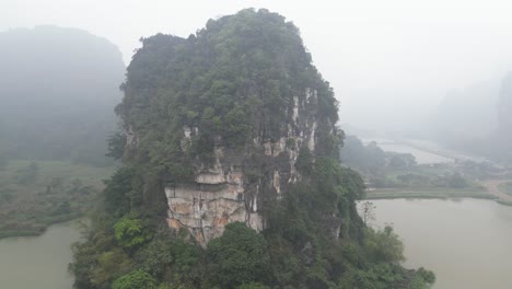 drone shot of dramatic cliffs surrounded by water in the mountainous region of ninh ninh in northern vietnam