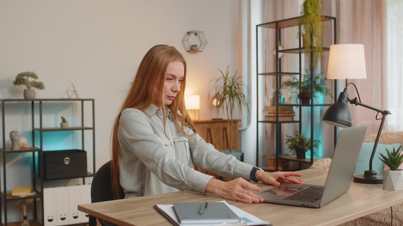 Caucasian businesswoman opening laptop and working on project sitting at home office table desk